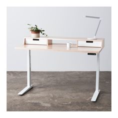 a desk with two drawers and a plant on top