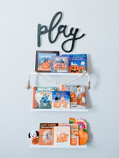 two shelves with books on them and the word play spelled in black