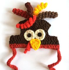 a crocheted hat with a bird on it's head and eyes, made to look like a turkey