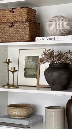 the shelves are filled with vases, pictures and other decorative items in baskets on them