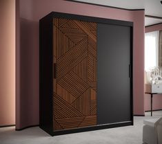 a black and brown cabinet in a pink room with a white chair next to it