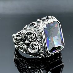 Elevate your style with this handcrafted men's ring featuring a mesmerizing mystic topaz gemstone. Crafted from 925K sterling silver, this ring boasts intricate engravings that add a touch of sophistication. The colorized topaz stone radiates a captivating brilliance, making it a true statement piece. Designed with meticulous attention to detail, this ring is a perfect blend of artistry and quality. Whether you're dressing up or keeping it casual, this ring will effortlessly complement your look. Indulge in the timeless elegance and treat yourself to this exceptional piece of jewelry. • Gender : Male / Female• Material : 925K Sterling Silver• Total weight : 19 Grams• Gemstone : Mystic Topaz Aquamarine Stone Ring, Emerald Stone Rings, Turkish Ottoman, Mystic Topaz Ring, Lapis Lazuli Ring, Men Ring, Citrine Stone, Aquamarine Stone, Mystic Topaz