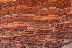 colorful rock formations in the desert, with brown and yellow stripes on it's sides