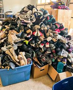 many pairs of shoes are stacked on top of each other in blue bins next to boxes