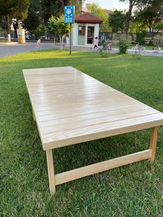 a wooden table sitting on top of a lush green field