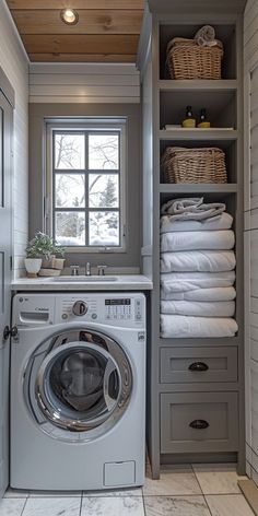 a washer and dryer in a small room with white tile on the floor