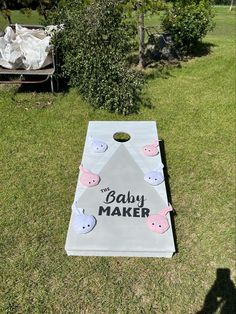 a baby maker themed cornhole game in the grass