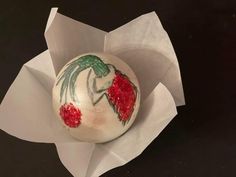 an ornament in the shape of a strawberry on top of some white paper