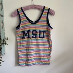 Super cool vintage rainbow striped Michigan State University tank top. Brand is Artex. 100% cotton.  Tagged size medium and measures 17.5 inches pit to pit and 24 inches long. Probably best for a modern small, maybe medium depending on desired fit.  Overall good vintage condition with a tiny mend on the S and a shortened hem  by the previous owner.  Please see last two photos for details. Retro Multicolor Tank Top, Retro Cotton Tank Top, Retro Summer Cotton Tank Top, Retro Cotton Tank Top For Summer, Multicolor Cotton Vest For Spring, Retro Multicolor Sleeveless Vest, 90s Sleeveless Cotton Tank Top, 90s Style Cotton Sleeveless Tank Top, 90s Style Sleeveless Cotton Tank Top