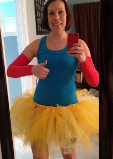 a woman in a blue tank top and yellow tutu is taking a selfie