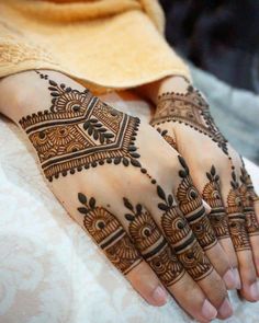 two hands with henna tattoos on them