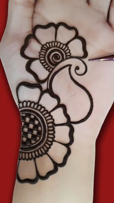 a woman's hand with henna tattoos on it