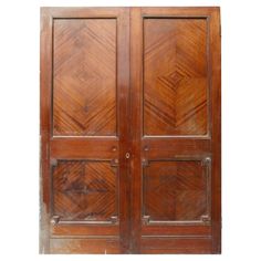 an old wooden double door with carved wood panels