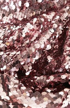 pink sequinized fabric with lots of small silver circles on it's surface