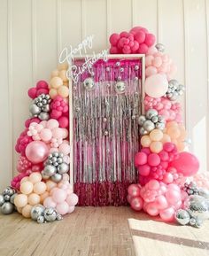 balloons and streamers decorate the entrance to a birthday party with pink, silver and white decorations