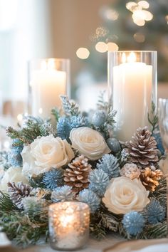 a centerpiece with candles, flowers and pine cones