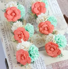 some pink and green flowers sitting on top of a piece of paper