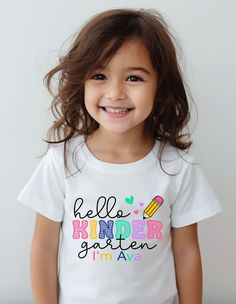 Hello School Shirt, Hello Kindergarten Shirt, Personalized Kids Name Shirt, Custom Grade Shirt, Pre-K School Shirt, Back To School Shirt Welcome to TeeDesignUS! We have selected the most special products for you and are at your service. We are here for everything you need. We wish you pleasant shopping! PRODUCT DETAILS We use Bella Canvas and Gildan SoftStyle brand shirts for printing. *Bella Canvas -unisex size -4.2 oz. -Solid colors are 100% Combed Cotton and Ring-Spinned Cotton. -Athletic Hea Cute Text Print Tops For School, White Text Print Shirt For School, Cute School Shirt With Name Print, Cute Crew Neck Shirt For End Of School Year, Cute Crew Neck Tops For End Of School Year, Cute Crew Neck Shirt With Name Print, Cute Cotton Shirt With Letter Print, Cute Long Sleeve T-shirt For School, Cotton Short Sleeve School Shirt