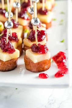 small appetizers with cranberry sauce and toothpicks on a white plate