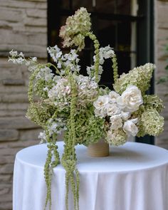 two vases filled with white flowers sitting on top of a table