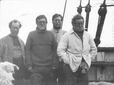 an old black and white photo of three men standing next to a dog on a boat