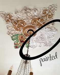 a chandelier hanging from the ceiling with words painted above it that read, pasted