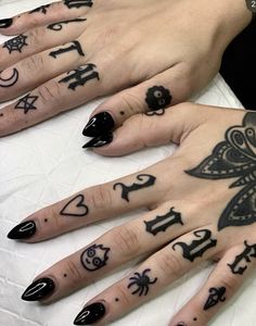 two hands with black and white tattoos on them