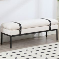 a black and white bench sitting on top of a hard wood floor next to a wall