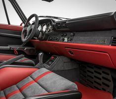 the interior of a sports car with red and black leather seats, steering wheel and dashboard