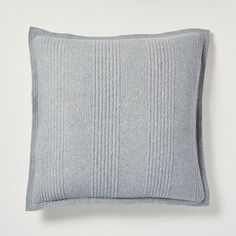 a light blue pillow sitting on top of a white wall