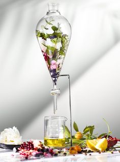 a vase filled with flowers sitting on top of a table next to a glass beaker