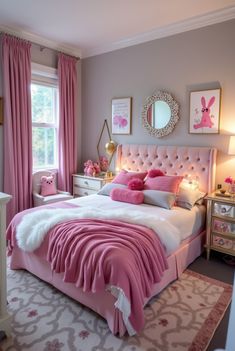 a bedroom decorated in pink and white with an upholstered headboard, bedding, rugs, lamps, and pictures on the wall