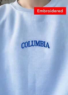 "Columbia" embroidered on a comfy cute crewneck. A sturdy and warm sweatshirt bound to keep you warm in the colder months. A pre-shrunk, classic fit sweater that's made with air-jet spun yarn for a soft feel and reduced pilling. Your new favorite sweatshirt! Cotton Campus Top With Letter Embroidery, Cotton Tops With Letter Embroidery For Campus, Embroidered Graphics Crew Neck Top, Crew Neck Top With Embroidered Text For College, Crew Neck Tops With Embroidered Graphics For Campus, Crew Neck Embroidered Graphics Tops For Campus, Long Sleeve Tops With Letter Embroidery For Campus, Basic Winter Tops With Embroidered Logo, White Collegiate Top With Embroidered Text