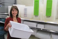 a woman holding a large white basket in a store