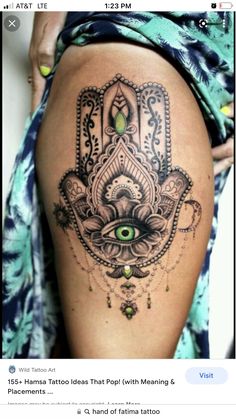 a woman's thigh with a hamsa tattoo on it