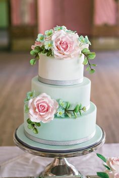 a three tiered cake with pink flowers on top