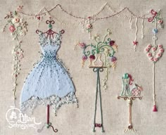 an embroidered dress is hanging on the wall next to other handmade items and beads