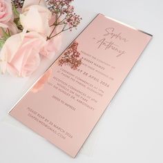 a pink wedding program with flowers on the side and an envelope for it to be folded