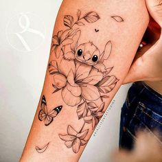 a woman's arm with flowers and butterflies on it