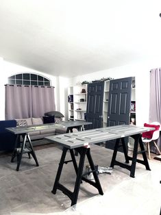 a living room filled with furniture next to a window covered in purple curtained drapes