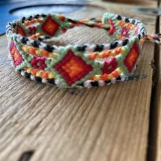 a colorful bracelet sitting on top of a wooden table