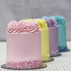 there are four different colored cakes on the table