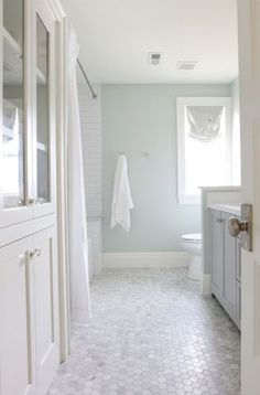 a white bathroom with hexagonal tile flooring