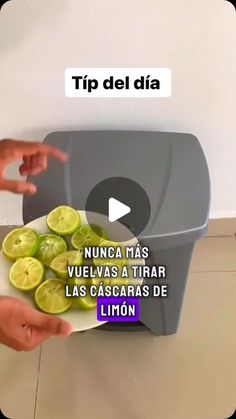 a person holding a plate with sliced limes on it and pointing to the side