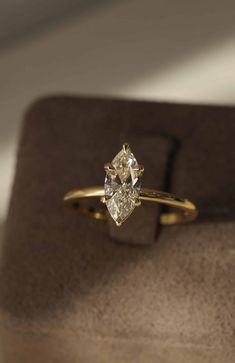 a diamond ring sitting on top of a wooden box