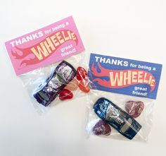 some candy wrapped in plastic on top of a white table with a pink and blue label