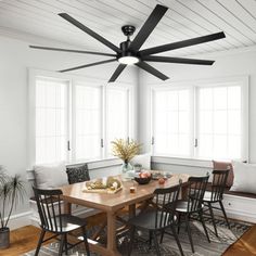 a dining room table with chairs and a ceiling fan in the middle of the room