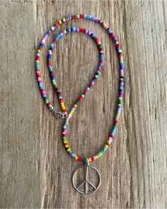 Spread good vibes wherever you go with this delightful peace sign necklace, handmade just for you. Crafted from gleaming sterling silver, the peace sign pendant hangs from a vibrant 16" necklace strung with colorful hippie love beads. https://kathybankston.com/products/peace-sign-necklace-with-hippie-love-beads Nickel Free Hippie Necklaces For Festivals, Hippie Nickel-free Necklaces For Festivals, Hippie Style Nickel-free Necklaces For Festivals, Bohemian Peace Sign Necklace For Gift, Silver Hippie Beaded Necklace For Festivals, Multicolor Spiritual Beaded Necklaces Nickel Free, Spiritual Multicolor Nickel-free Beaded Necklace, Multicolor Nickel-free Spiritual Beaded Necklace, Nickel-free Multicolor Spiritual Beaded Necklace