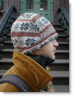 a man wearing a beanie standing in front of some stairs