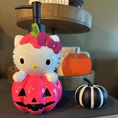 the hello kitty pumpkin is next to an orange and black pumpkin